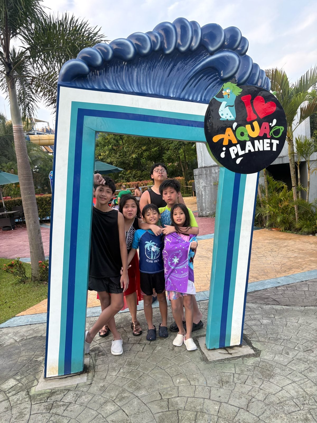 Family at the Aqua Planet entrance arch in Clark
