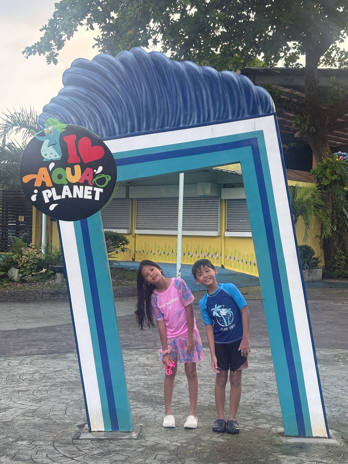 The twins at the I ❤️ Aqua Planet arch.