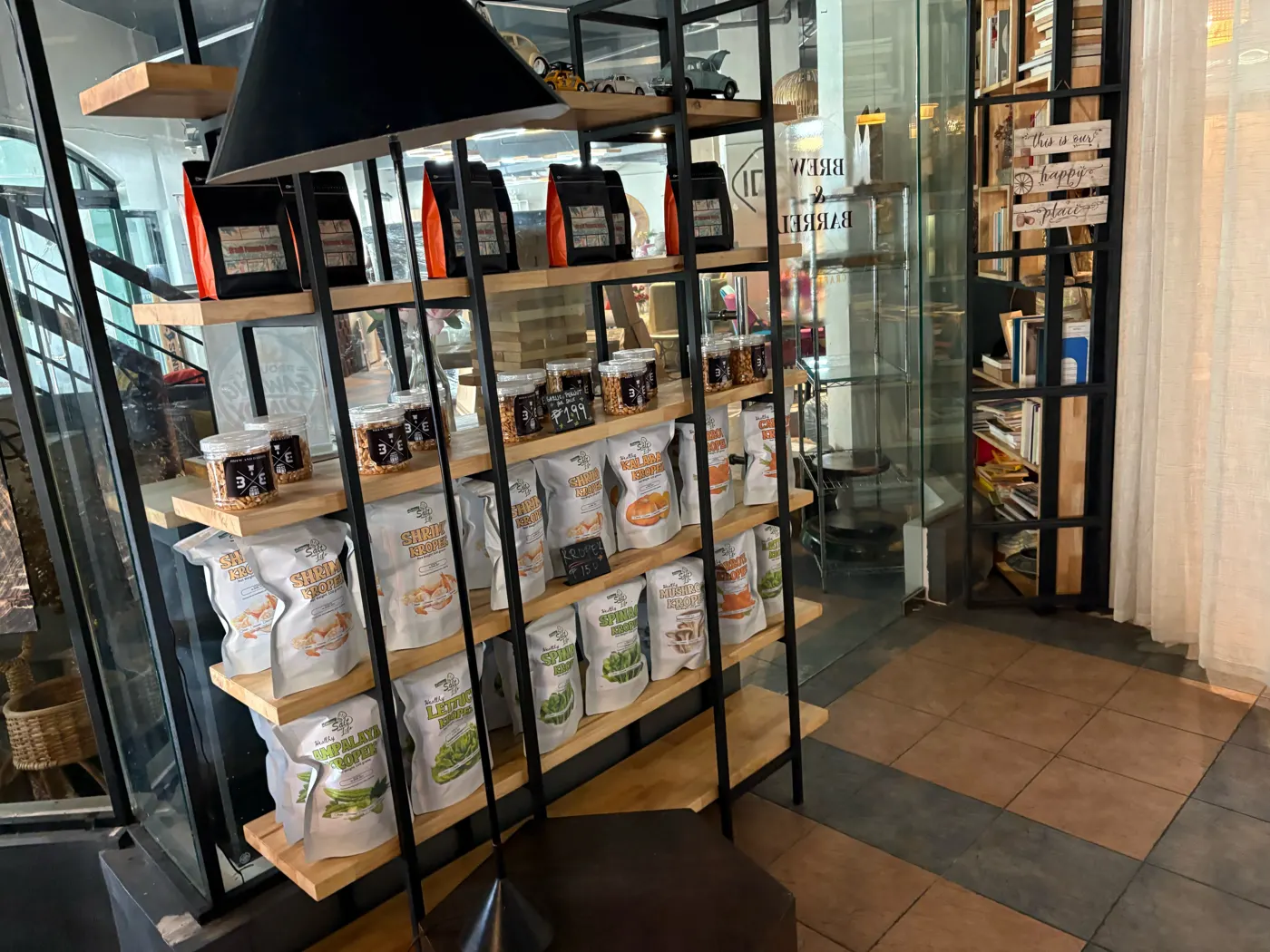 Shelf of coffee bags, nuts and kropek snacks for sale at Brew and Barrel New Manila