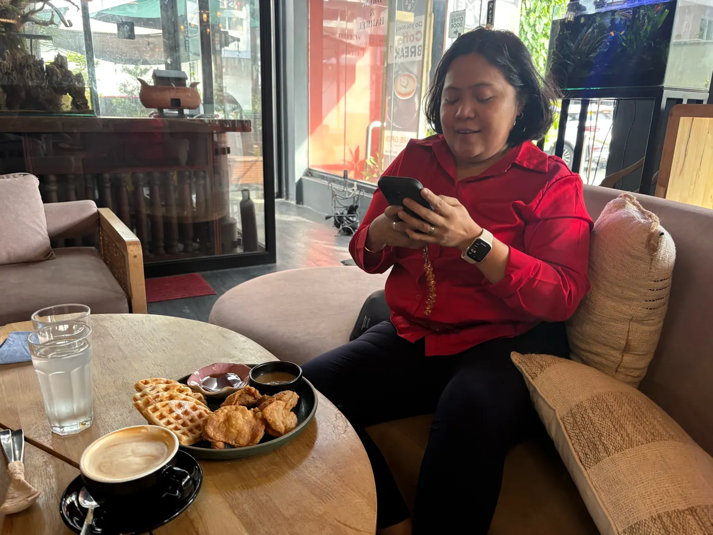 Dimple taking a photo of her chicken and waffles at Brew and Barrel