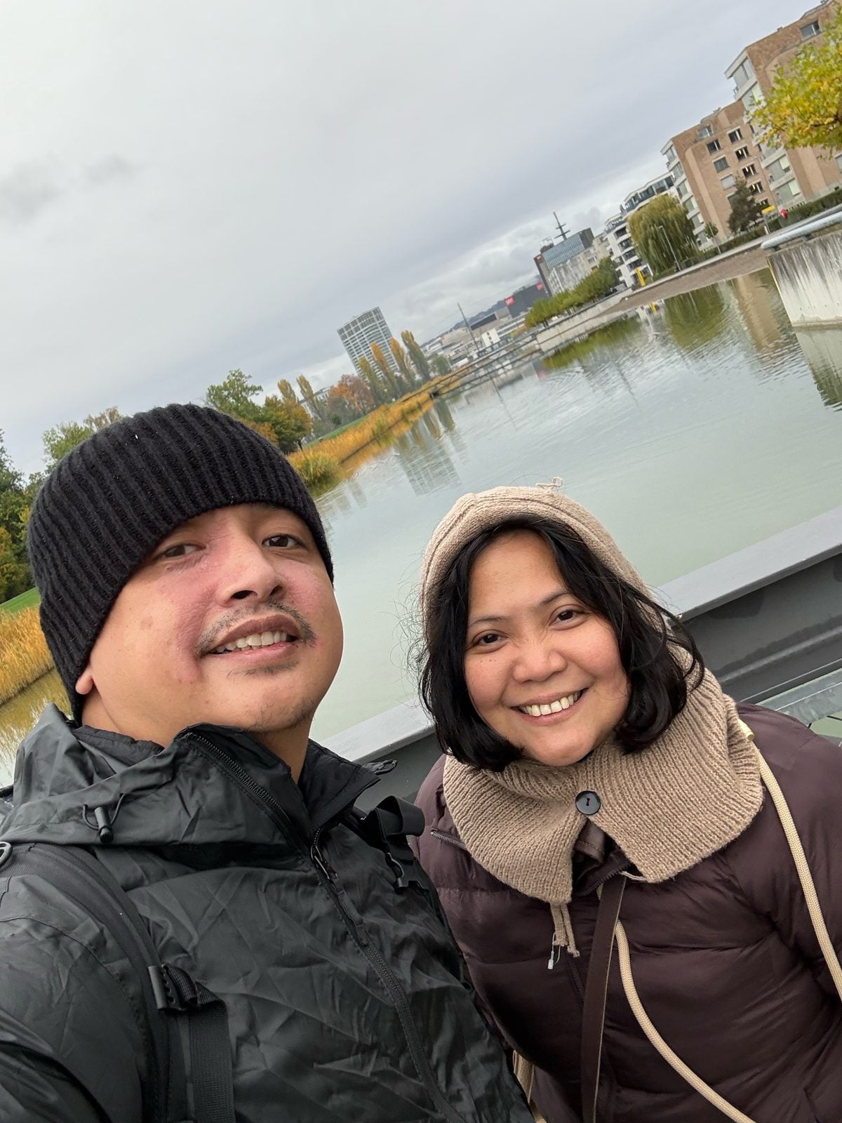 Paolo and Rosed on a bridge in Zurich with autumn trees behind them