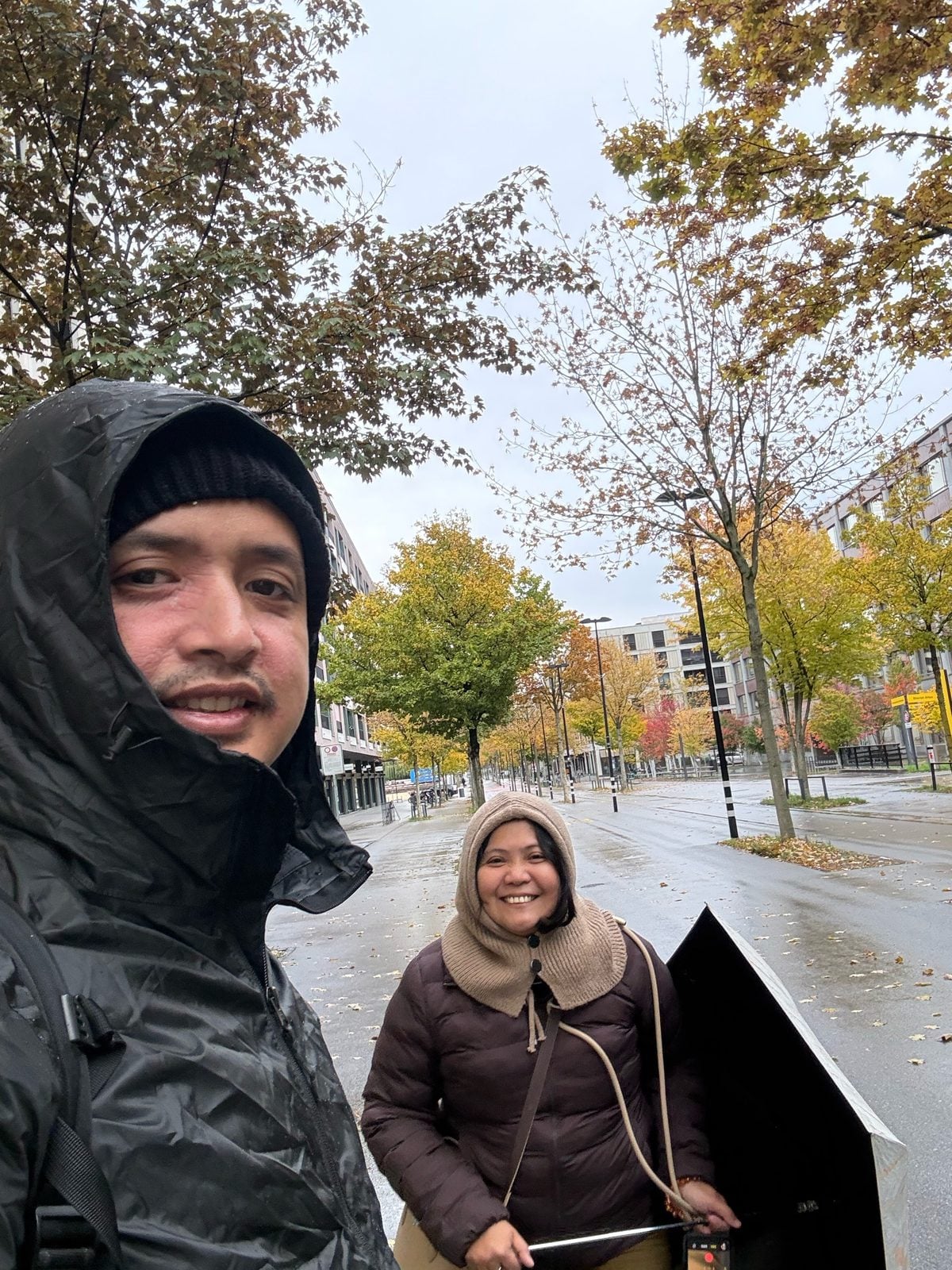 Paolo and Rosed bundled up on a rainy, leafy Zurich street