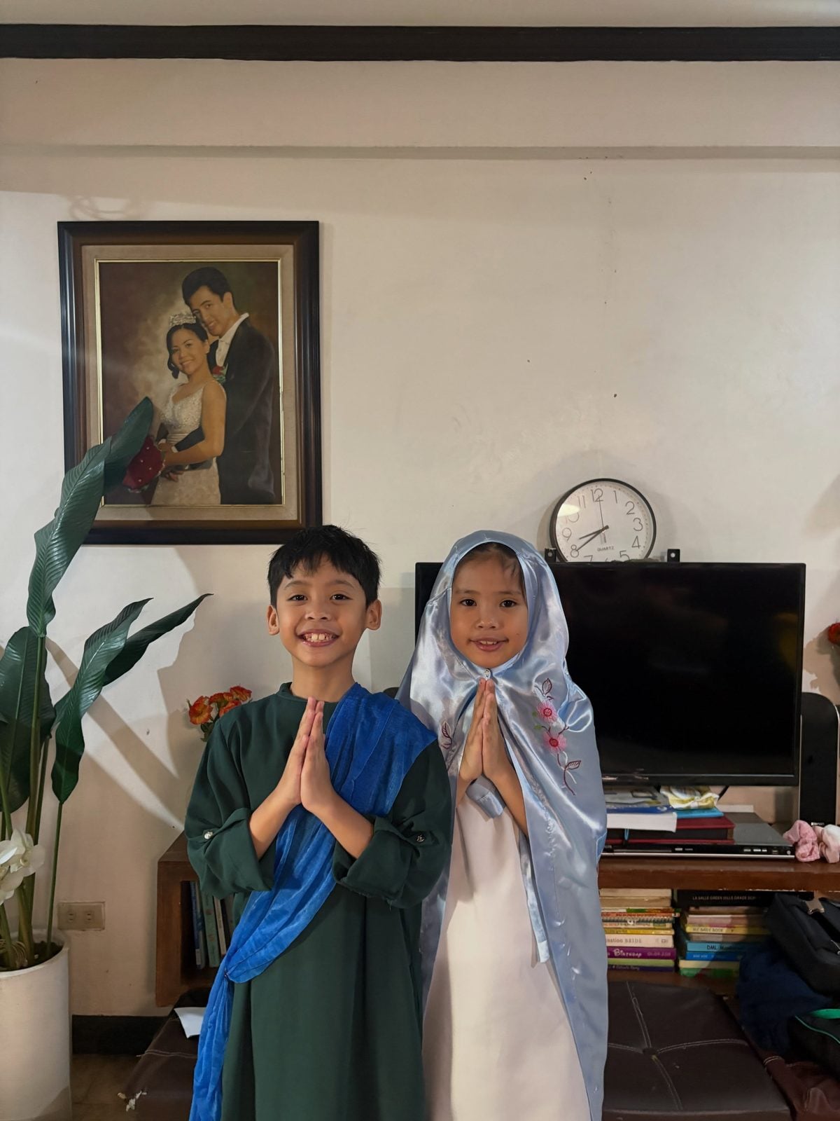 Sky and Chloe dressed as Papa Joseph and Mama Mary, hands folded in prayer