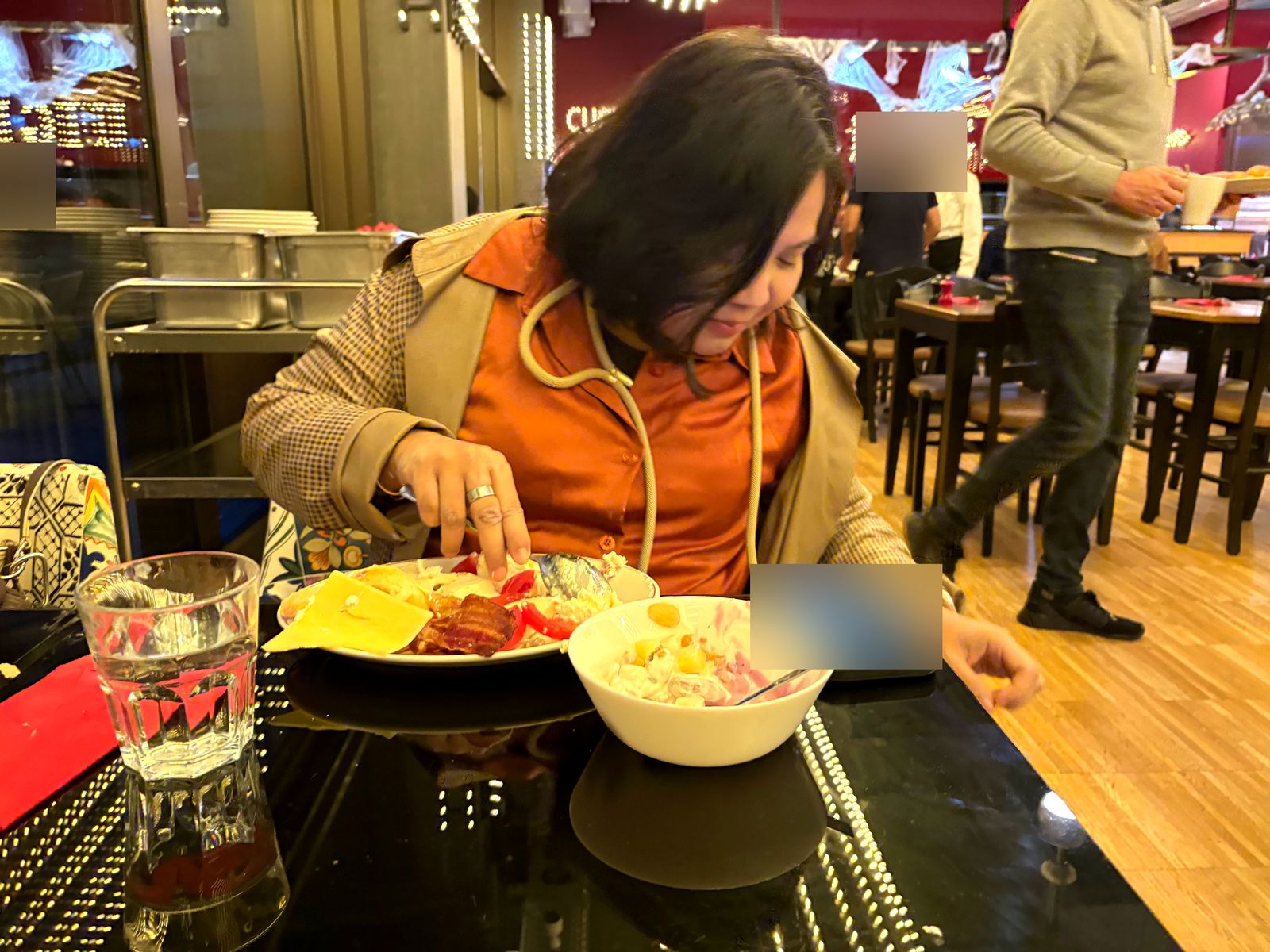 Dimple digging into bacon, cheese, tomatoes and eggs, with a bowl of yogurt and fruit