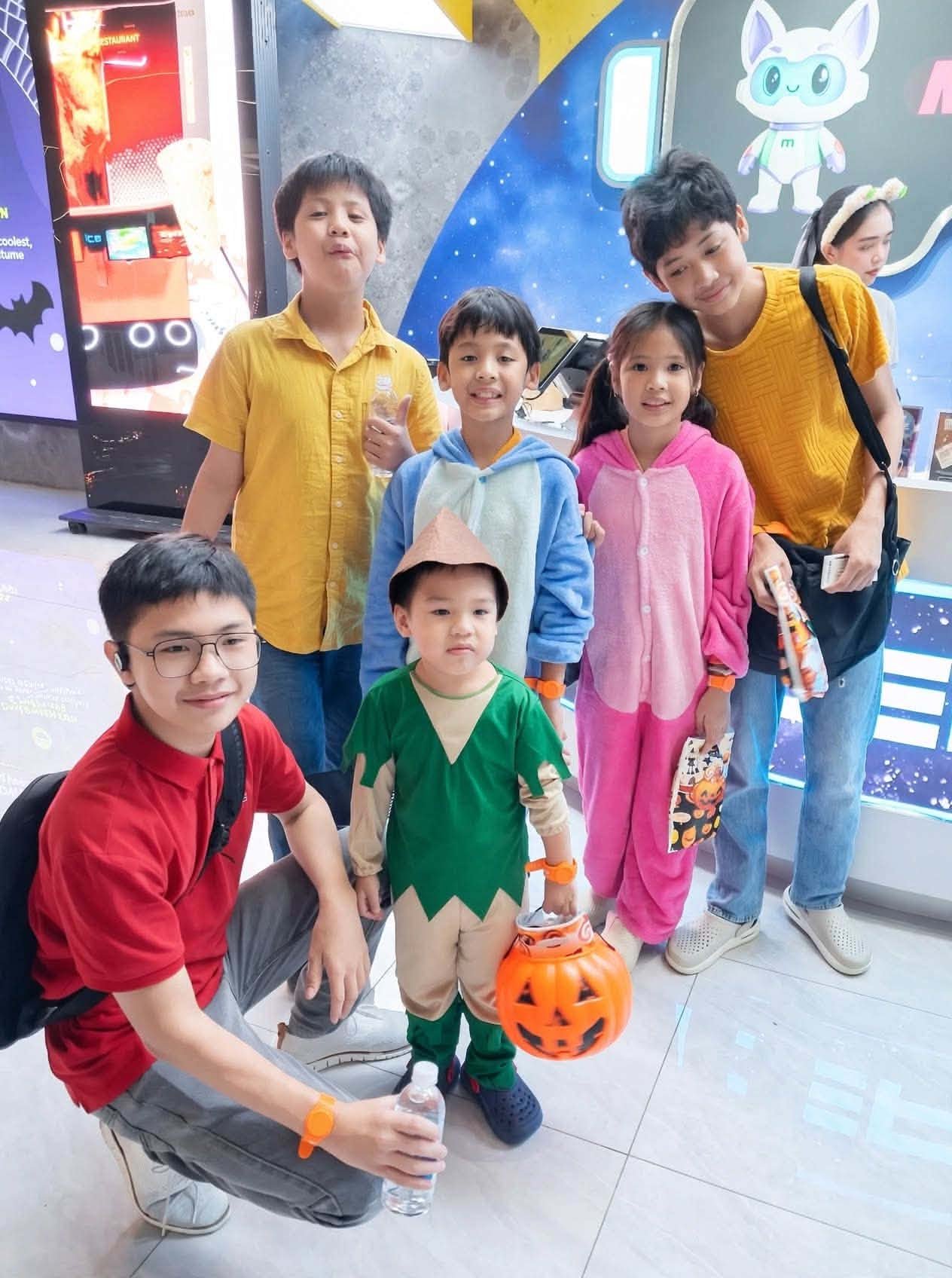 The kids in Halloween costumes at Mettacity with a pumpkin bucket