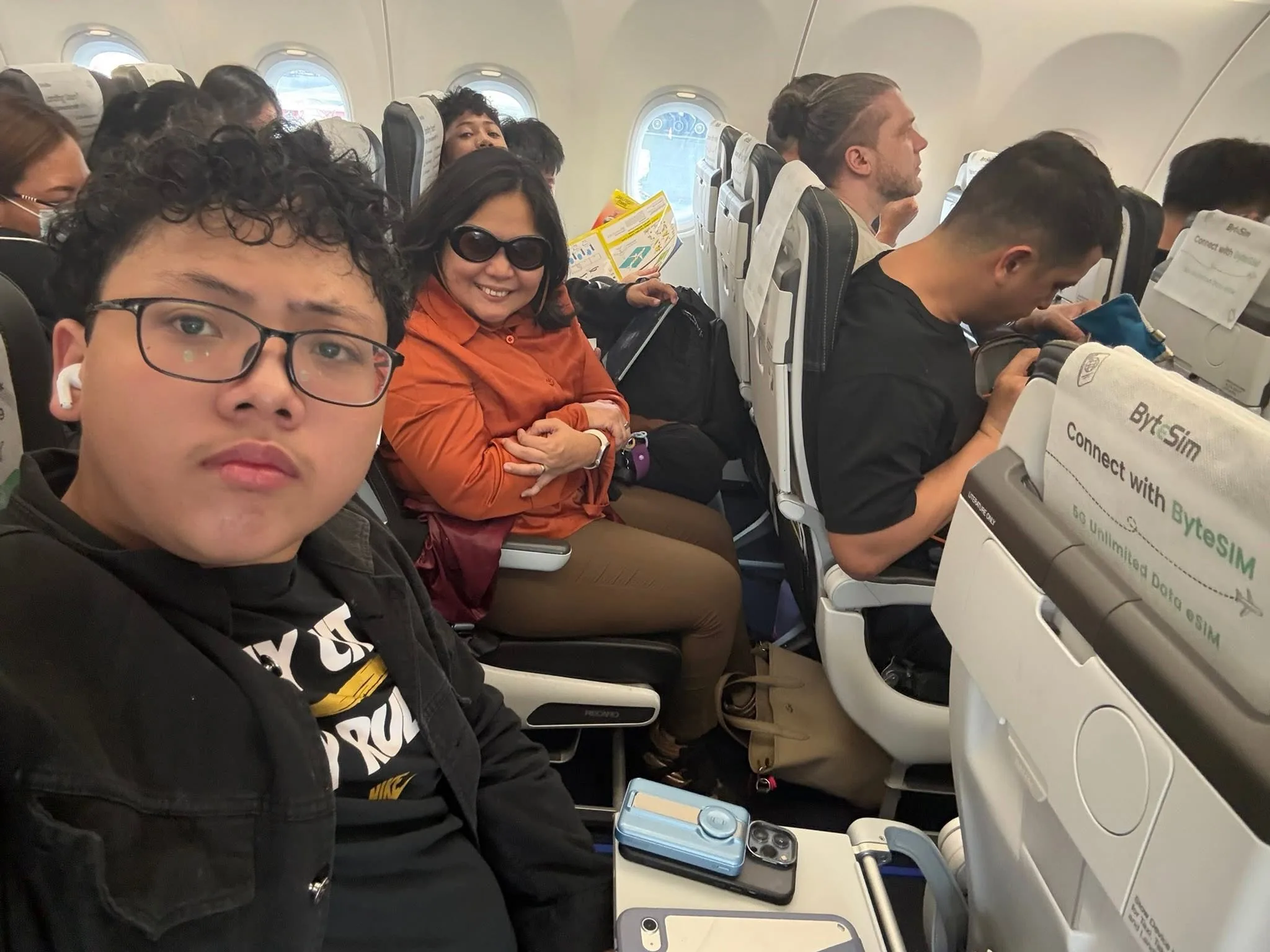 Kids smiling in their seats after boarding at NAIA Terminal 3 for Singapore
