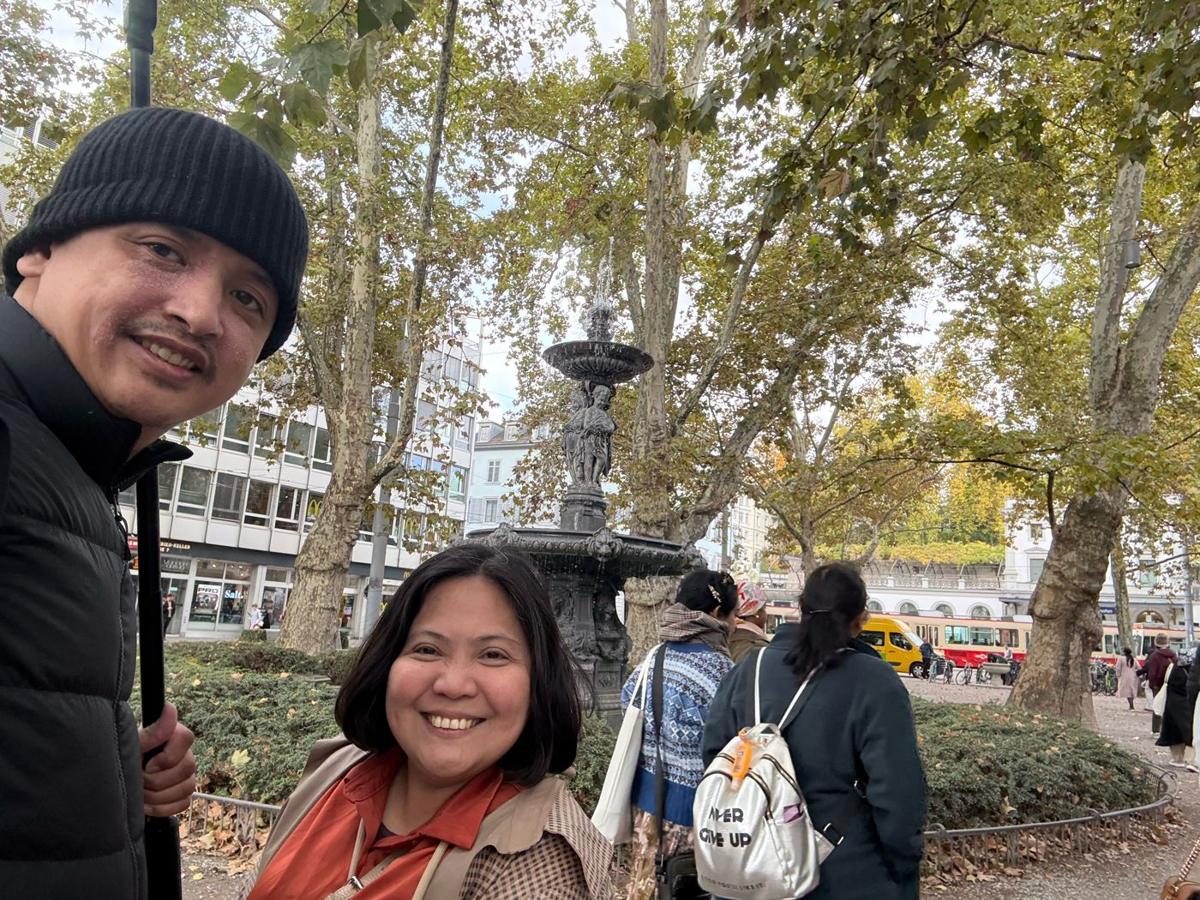 Selfie by a fountain under autumn trees in Zurich