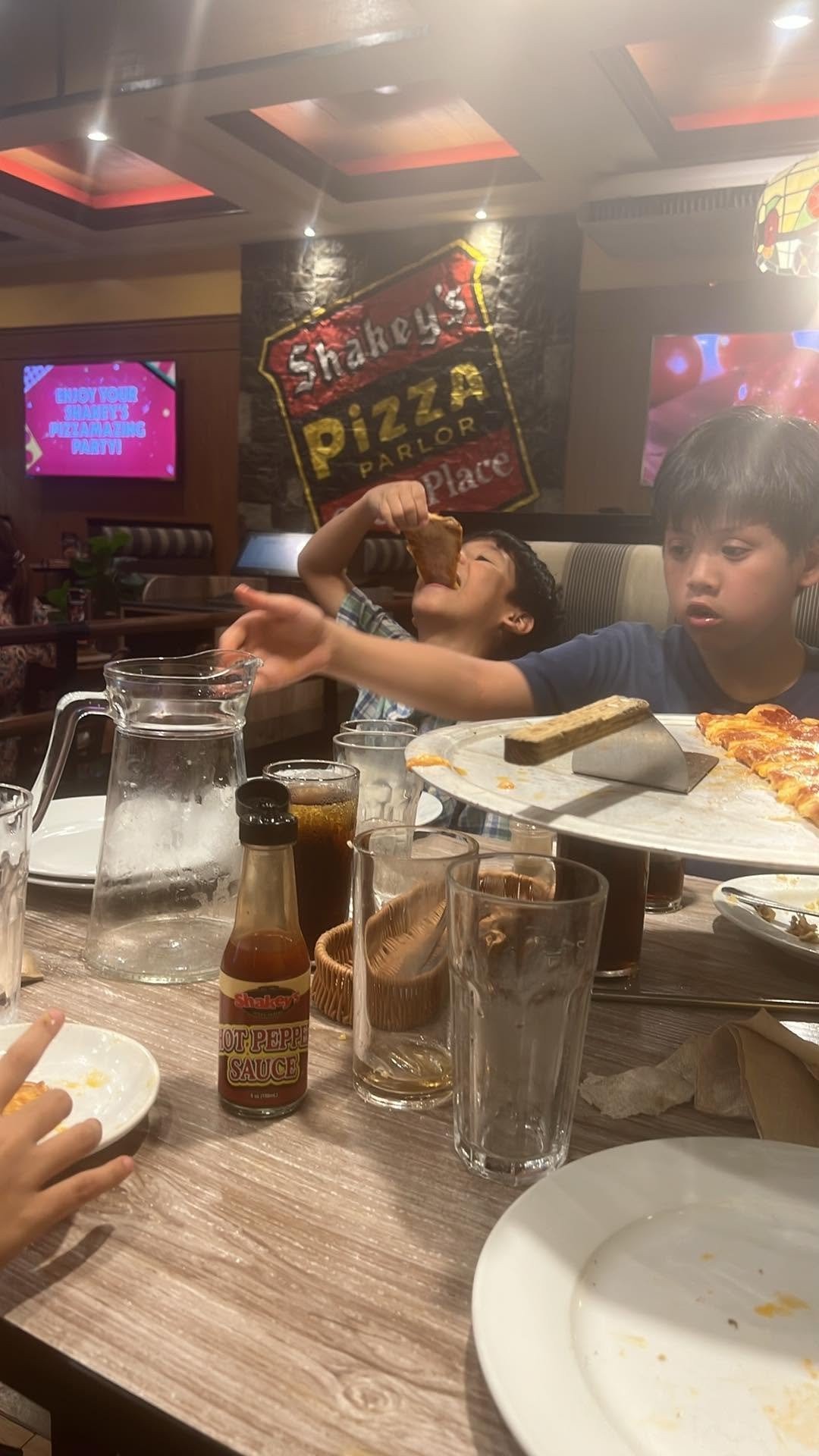 The siblings under the Shakey's Pizza Parlor sign