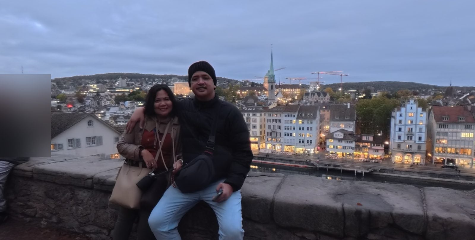 Sitting on the old stone wall at Lindenhof above the Limmat