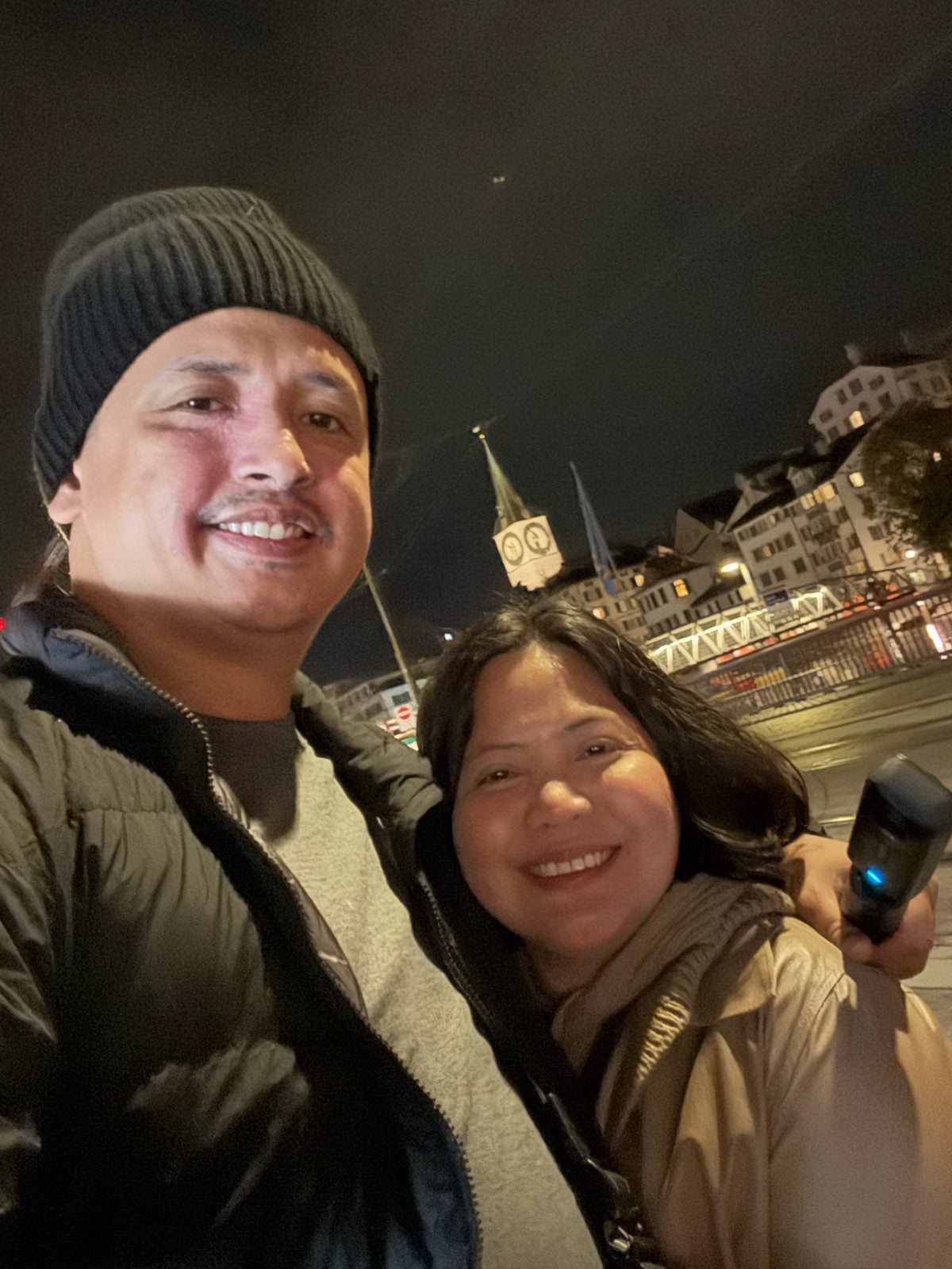 Night selfie by the Limmat with the lit St. Peter's clock tower, Zurich