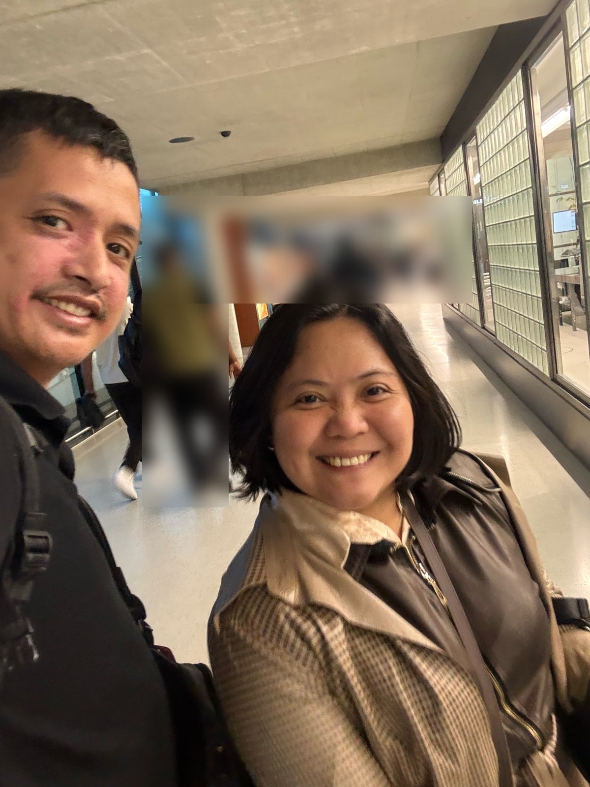 Paolo and Rosed smiling in the arrivals walkway at Zurich Airport