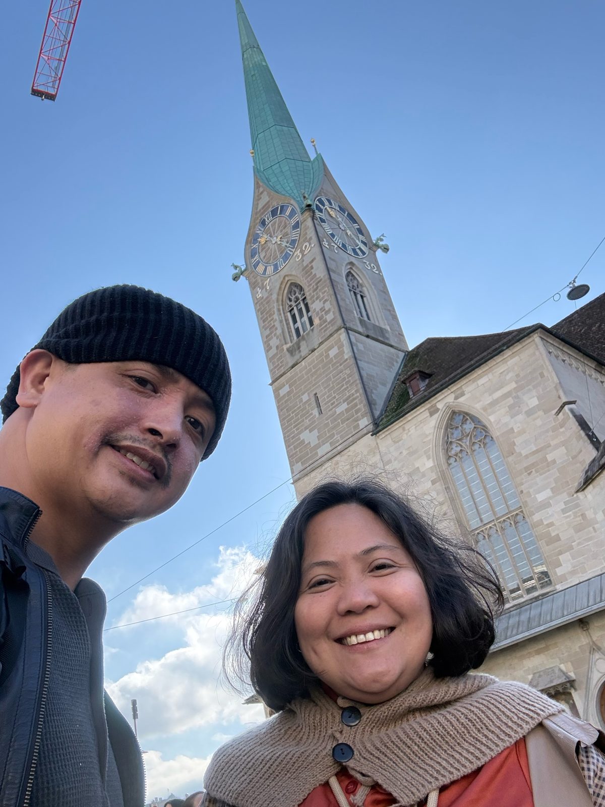 Paolo and Dimple below the Fraumünster spire and clock tower