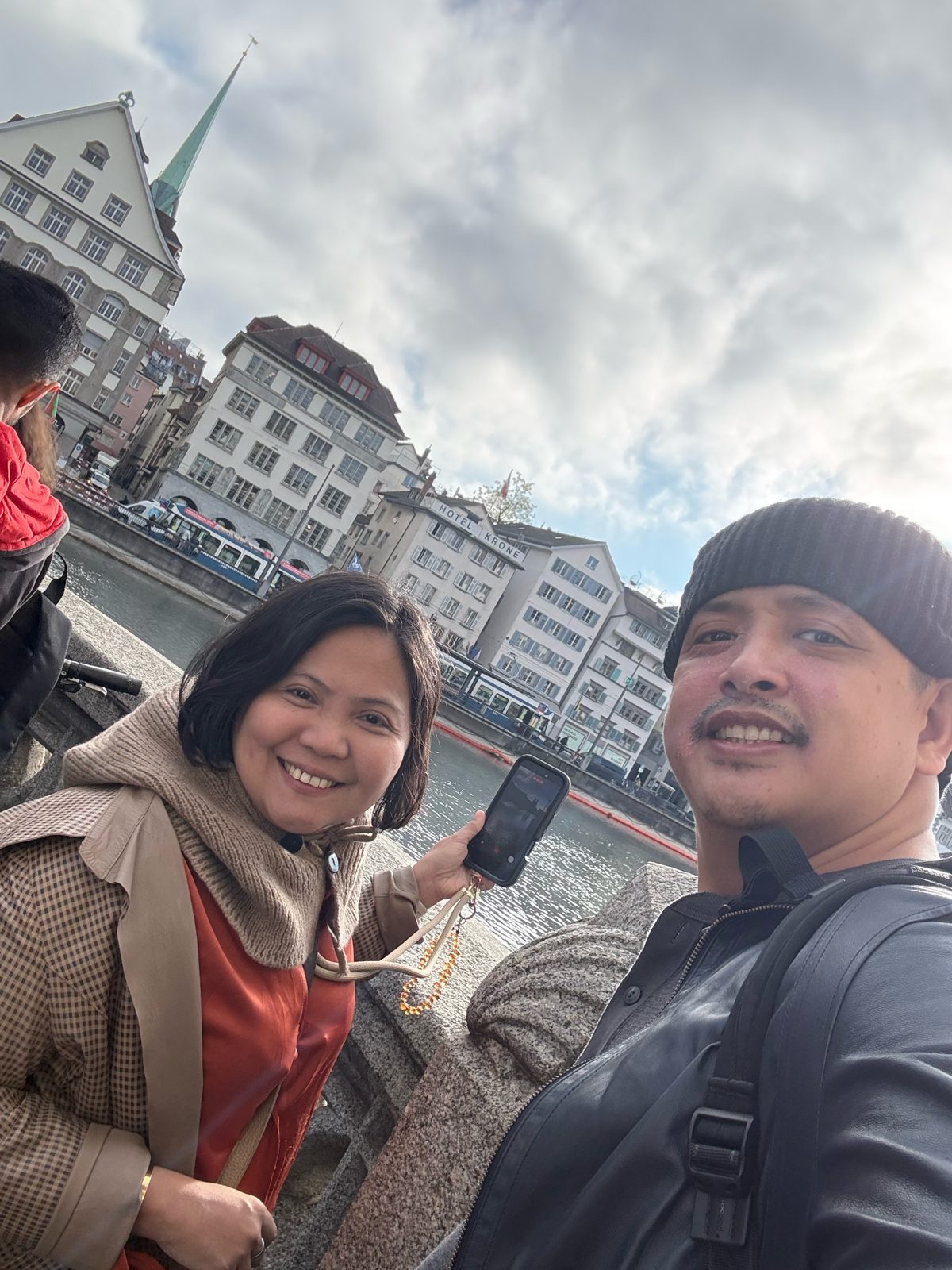 Dimple and Paolo by the Limmat river with Hotel Krone and the Fraumünster spire behind